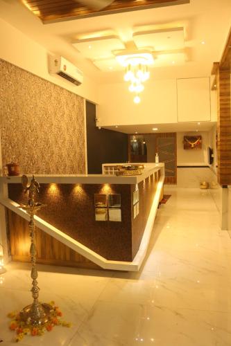 a lobby with a counter and a cross on the floor at Hotel Palm Beach Pride in Mumbai