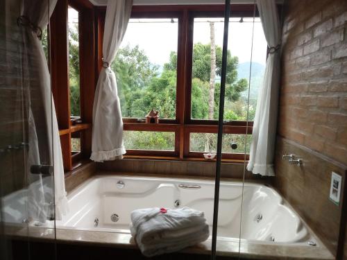 a bath tub in a bathroom with a window at Colline Verte in Monte Verde
