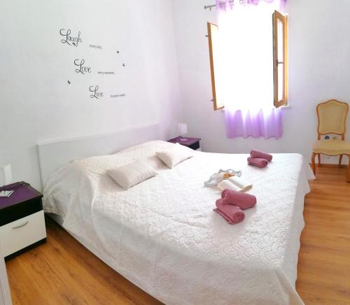 a bedroom with a bed with two stuffed animals on it at Holiday Home Blue Dream in Putniković