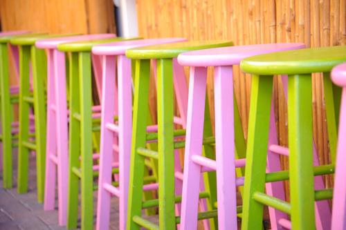a row of pink and green stools in a row at Old Colorado Inn in Stuart