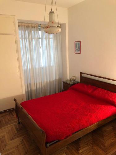 una camera con letto rosso e finestra di Excelente depto. para 5 personas. Zona ideal !! a Mar del Plata