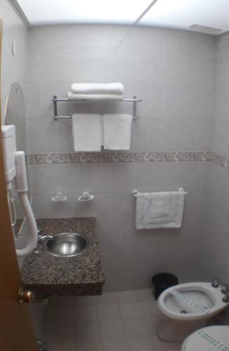 a bathroom with a sink and a toilet and towels at KRAKUS in San Bernardo