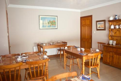 a dining room with wooden tables and chairs at Anchor House Accommodation in Newport