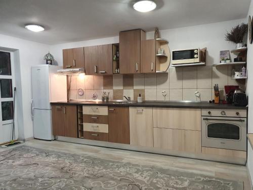eine Küche mit Holzschränken und einem weißen Kühlschrank in der Unterkunft Casa Lucky in Râșnov