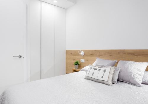 マドリードにあるMalasaña Apartment by Flatsweethomeの白いベッドルーム(白いシーツと枕付きのベッド1台付)