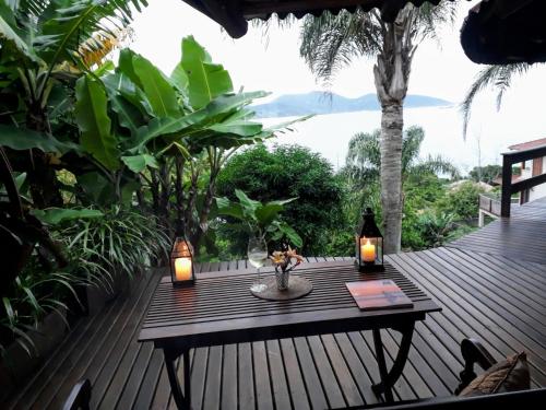 a wooden deck with a table with lights on it at Luxury Suites Vila Indonésia in Garopaba
