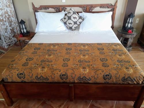 ガロパバにあるLuxury Suites Vila Indonésiaのベッドルーム1室(ベッドカバー、枕付)
