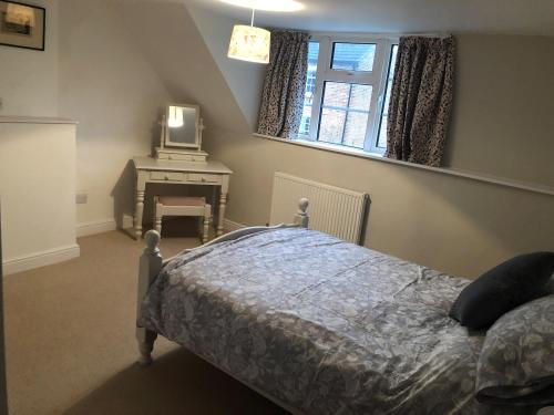 a bedroom with a bed and a tv and a window at Sunnyside Cottage in Sleaford