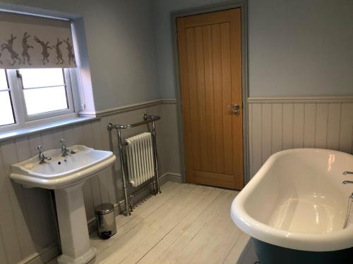 uma casa de banho com um lavatório e uma banheira em Sunnyside Cottage em Sleaford