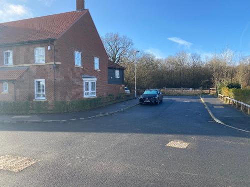 a car parked in front of a brick house at Stansted Coach House - Apartment Hotel in Elsenham