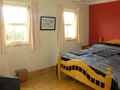 um quarto com uma cama e duas janelas em Scenic Estuary Way Home in Labasheeda em Labasheeda