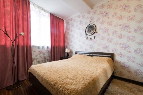 a bedroom with a bed and a window with flowers at Nadezhda Apartments on Keremet street in Almaty