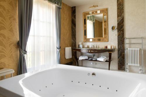 a bathroom with a large tub and a sink at Villa Cordevigo in Cavaion Veronese