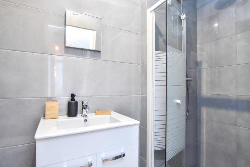 une salle de bain blanche avec un lavabo et une douche dans l'établissement Superb apartment - 6P- Center of Paris, à Paris