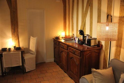 - une cuisine avec une commode en bois et un four micro-ondes dans l'établissement Studio Julianne place Sainte Catherine, à Honfleur