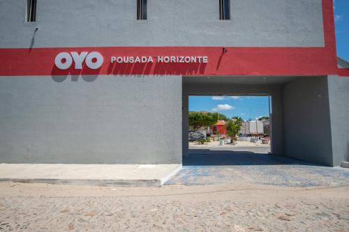 un edificio con un cartello rosso e bianco di OYO Pousada Horizonte a Horizonte