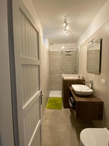 a bathroom with a toilet and a sink and a door at Residence Bellavista in Fondo