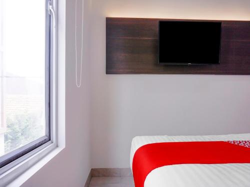 una camera con letto e TV a parete di Super OYO 90115 Near Pasar Baru a Giacarta