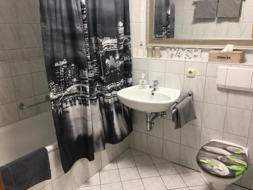 a bathroom with a sink and a shower curtain at weitnaustyle in Weitnau