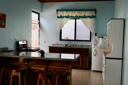 a kitchen with a white refrigerator and a counter top at Las Pavitas Arenal Suites in Fortuna
