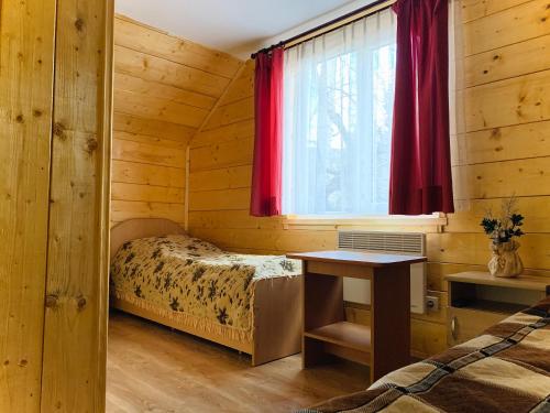 a room with two beds and a window in a log cabin at За горбами in Yaremche