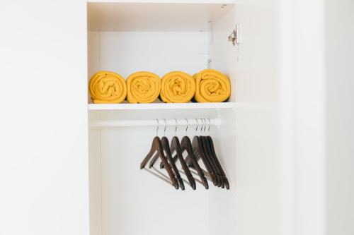 a white shelf with yellow plates and forks at HEIMATEL - Suiten, Apartments und Studios in Scheidegg