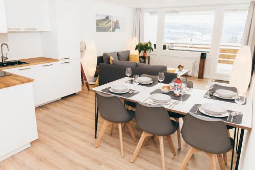 a kitchen and a dining room with a table and chairs at HEIMATEL - Suiten, Apartments und Studios in Scheidegg