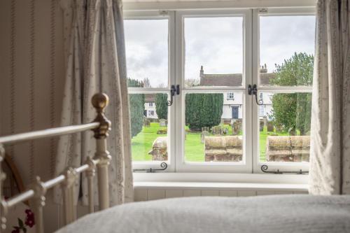ein Schlafzimmer mit einem Fenster mit Blick auf einen Hof in der Unterkunft Gothic House Cottage in Clare