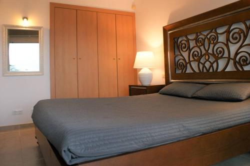 een slaapkamer met een groot bed met een houten hoofdeinde bij Apartamento en Roses con vistas al canal y piscina in Roses