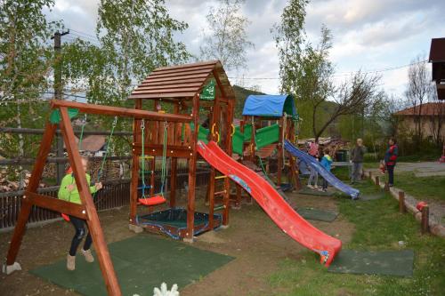 a playground with a slide and a play structure at Pensiunea Moldovan in Praid