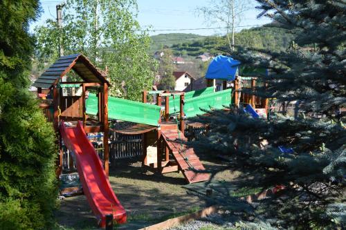a childrens playground with a slide and a play structure at Pensiunea Moldovan in Praid