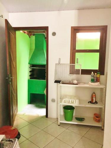 a kitchen with green paint on the walls at Castelo da Ilha in Florianópolis