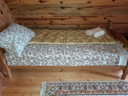 uma cama num chalé de madeira com uma almofada e um tapete em Holiday Home Ema em Plešin