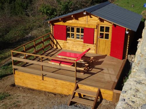 a small cabin with a deck and a chair at Domaine des hauts de Vernon in Vernon