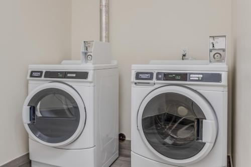 two washing machines sitting next to each other in a room at Americas Best Value Inn & Suites Katy in Katy