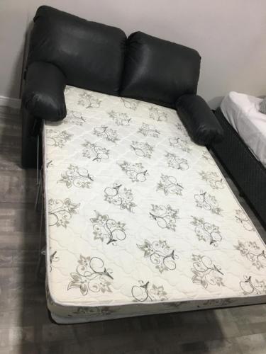 a couch with a blanket on top of it at Flat -Hidromassagem privativa e Piscina a 500 mts da praia in São Vicente