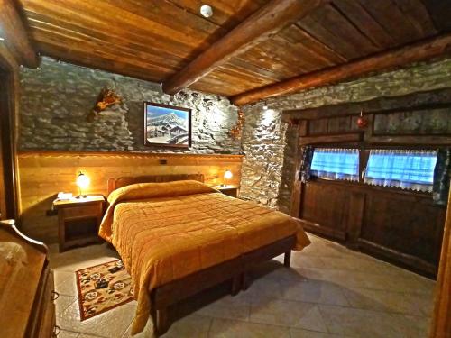 a bedroom with a bed and a stone wall at Etoile des Neiges in Sauze dʼOulx