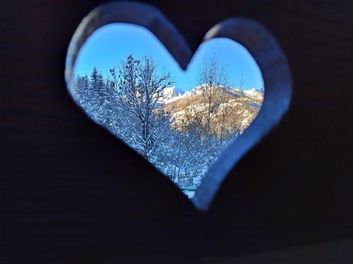 a heart shaped view of trees and a mountain at Etoile des Neiges in Sauze dʼOulx