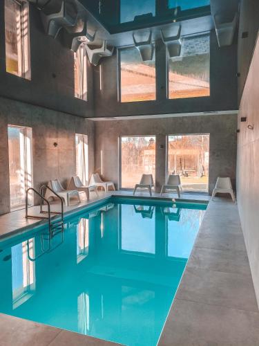 a swimming pool with chairs in a building at La Park Aparthotel in Kudowa-Zdrój