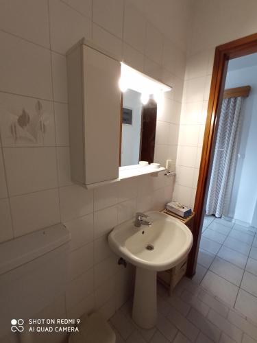 a white bathroom with a sink and a mirror at Snuggery Elegant Apartment in Ayios Nikolaos Sithonia