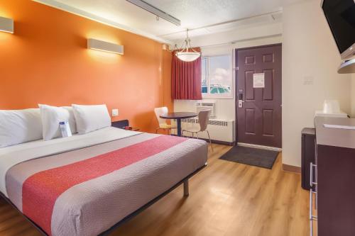 a hotel room with a bed and a table at Motel 6-Lethbridge, AB in Lethbridge