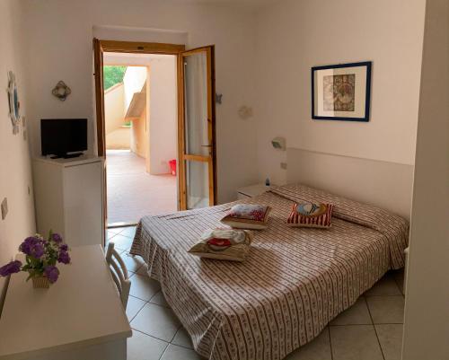 a small bedroom with two beds and a television at Marta's Holidays Home in Nisporto