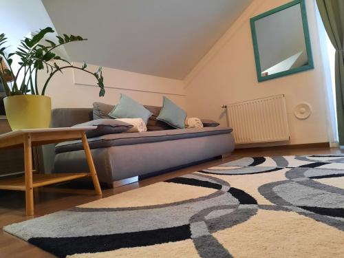 ein Wohnzimmer mit einem Sofa und einem Teppich in der Unterkunft Kamilla Apartman Villapark in Bük