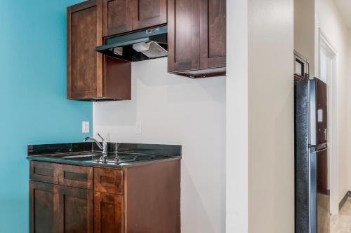 eine Küche mit Holzschränken und einem Waschbecken in der Unterkunft Red Lion Inn & Suites Katy in Katy