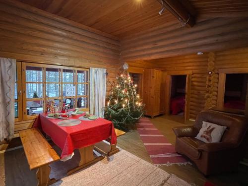 a room with a table with a christmas tree in it at Säilöksen Lomahuvilat in Luhanka