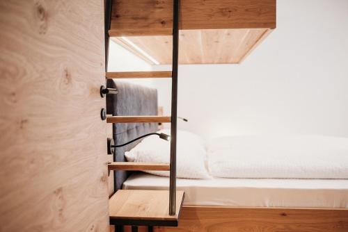 a room with a bed and a mirror at Höllerhof Brixen in Albes