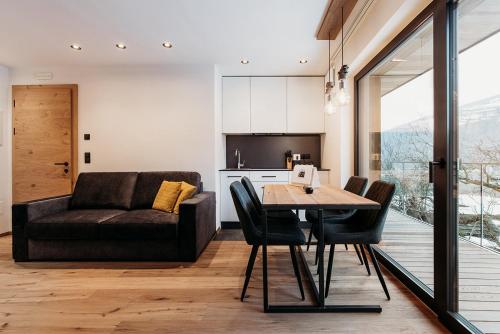 a living room with a table and a couch at Höllerhof Brixen in Albes
