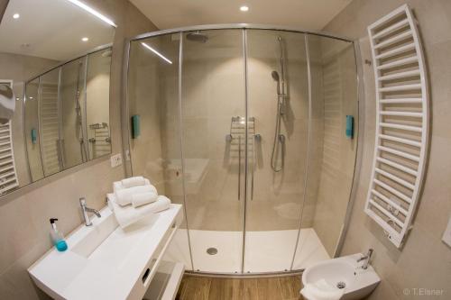 een badkamer met een douche, een wastafel en een toilet bij Hotel Ariston in Caorle