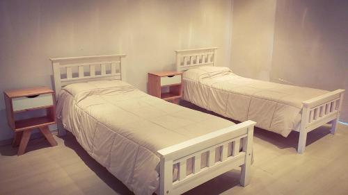 2 camas blancas en una habitación con 2 mesitas de noche en NorthBeach en Colón