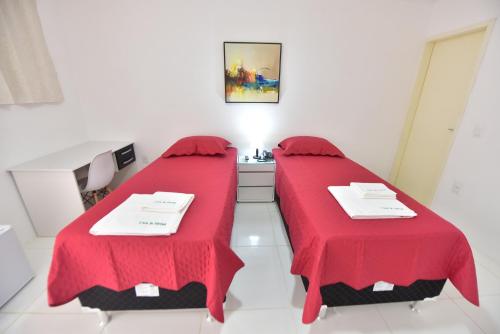 two beds in a room with red covers at LIVE IN FORTALEZA HOTEL in Fortaleza